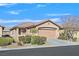Single-story house with tan exterior, two-car garage, and desert landscaping at 6072 Isola Peak Ave, Las Vegas, NV 89122