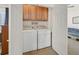 Well-lit laundry room with washer, dryer, and cabinets at 6072 Isola Peak Ave, Las Vegas, NV 89122