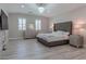 Luxurious main bedroom featuring a plush bed, wood-look floors, and large windows at 6788 Lavender Sky Ct, Las Vegas, NV 89142