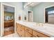 Bathroom with double sinks, a large mirror, and a view of a bedroom at 7015 N Jensen St, Las Vegas, NV 89149