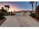 Home exterior with three-car garage and landscaping at 7015 N Jensen St, Las Vegas, NV 89149