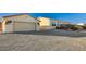 Single-story home with attached garage and a spacious gravel driveway at 7015 N Jensen St, Las Vegas, NV 89149