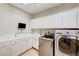 Laundry room with washer, dryer, and ample cabinet space at 7015 N Jensen St, Las Vegas, NV 89149