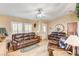 Living room boasts leather sofas, tile floors, and a ceiling fan at 7015 N Jensen St, Las Vegas, NV 89149