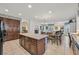 A kitchen features a central island, cabinets, tile flooring, chandelier lighting, and extends into the living area at 8216 Wooden Windmill Ct, Las Vegas, NV 89131