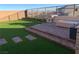 Landscaped backyard with artificial turf, patio, and sitting area at 12381 Foxtail Run Ave, Las Vegas, NV 89138