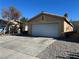 Front view of a house with a white garage door and gravel driveway at 1420 Arlington Heights St, Las Vegas, NV 89110