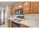 Kitchen with wood cabinets, black appliances, and gas cooktop at 1473 Teddington Ct # 101, Las Vegas, NV 89102