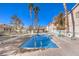 Community pool with surrounding fence and palm trees at 1473 Teddington Ct # 101, Las Vegas, NV 89102