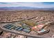 Aerial view of community with tennis courts, a clubhouse, a pool, and desert mountain landscape at 1510 Fieldbrook St, Henderson, NV 89052