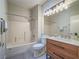 Bright bathroom featuring a shower-over-tub, modern vanity, white countertops, and a large mirror with decorative lighting at 1510 Fieldbrook St, Henderson, NV 89052