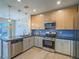 Modern kitchen features stainless steel appliances and blue tile backsplash at 1510 Fieldbrook St, Henderson, NV 89052