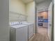 Laundry area with washer, dryer and shelving; kitchen view at 1510 Fieldbrook St, Henderson, NV 89052