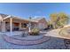 Landscaped backyard with a covered patio and gravel pathway at 1656 Black Fox Canyon Rd, Henderson, NV 89052