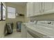 Bright laundry room with washer, dryer, and cabinets at 1656 Black Fox Canyon Rd, Henderson, NV 89052