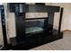 Elegant black granite fireplace with glass doors and a large hearth at 2000 White Falls St, Las Vegas, NV 89128