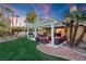 Landscaped backyard oasis with a pergola, seating area, and lush greenery at 2228 Lucerne Ct, Henderson, NV 89014