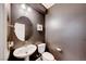 Powder room with pedestal sink, round mirror, and dark walls at 2844 Alenga St, Henderson, NV 89044