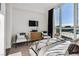 Spacious bedroom with two chairs, large TV, and city views at 2857 Paradise Rd # 2203, Las Vegas, NV 89109