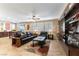 Living room with leather couches, coffee table, built-in entertainment center, and large TV at 3158 Biancavilla Ave, Henderson, NV 89044