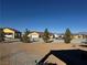 Single-story yellow house with a garage and covered parking area at 3720 W Charleston Park Ave, Pahrump, NV 89048