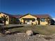 Single story house with a landscaped lawn and palm trees at 3720 W Charleston Park Ave, Pahrump, NV 89048