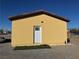 Small yellow storage shed with a white door at 3720 W Charleston Park Ave, Pahrump, NV 89048