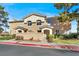 Tan two-story townhome with a landscaped yard and two-car garage at 503 Fragrant Orchard St, Henderson, NV 89015