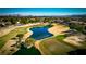 Aerial view of homes and golf course with pond and city skyline in background at 52 Innisbrook Ave, Las Vegas, NV 89113