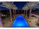 Expansive pool and patio area with palm trees and night lighting at 52 Innisbrook Ave, Las Vegas, NV 89113