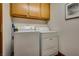 Bright laundry room, featuring washer, dryer, and overhead cabinets at 5242 Dickens Dr, Las Vegas, NV 89119