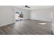 Sunlit living room featuring grey vinyl flooring and sliding glass doors at 5264 Lookout St, Las Vegas, NV 89120