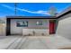 Mid-century modern home with a red door and gray exterior at 6252 Fairwood Ave, Las Vegas, NV 89107