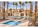 Community pool and spa with lounge chairs and palm trees at 6861 Tamarus St # 203, Las Vegas, NV 89119