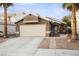 Single-story house with a two-car garage and landscaped front yard at 7336 Young Doe Ave, Las Vegas, NV 89130