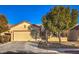 Single-story house with a beige exterior, two-car garage, and landscaped front yard at 7824 Homing Pigeon St, North Las Vegas, NV 89084