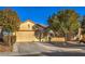 Single-story house with a beige exterior, two-car garage, and landscaped front yard at 7824 Homing Pigeon St, North Las Vegas, NV 89084