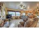 Living room with tile floors, brown couches, and a large TV at 7824 Homing Pigeon St, North Las Vegas, NV 89084