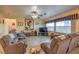 Living room with brown couches, a large TV, and a tiled floor at 7824 Homing Pigeon St, North Las Vegas, NV 89084