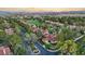 Stunning aerial of a community with lush trees, red-tiled roofs, and a golf course in the background at 8199 Pinnacle Peak Ave, Las Vegas, NV 89113