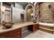 Elegant bathroom with stone accents, a soaking tub, and a stylish vanity at 8199 Pinnacle Peak Ave, Las Vegas, NV 89113