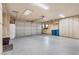 Three-car garage featuring built-in storage cabinets along the wall and epoxy flooring at 8199 Pinnacle Peak Ave, Las Vegas, NV 89113