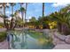 Beautiful pool with rock features and mature trees, creating a serene and natural backyard retreat at 8199 Pinnacle Peak Ave, Las Vegas, NV 89113