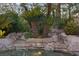 An in-ground pool with rock waterfalls and lush landscaping at 8199 Pinnacle Peak Ave, Las Vegas, NV 89113