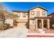 Two-story house with tan siding, stone accents, and a two-car garage at 8672 Big Sagebrush Ave, Las Vegas, NV 89117