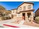 Two story home with tan exterior, red door and a two car garage at 8672 Big Sagebrush Ave, Las Vegas, NV 89117