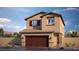 Two-story house with brown garage door and tan exterior at 9986 Ullom Dr # 14, Las Vegas, NV 89141