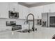 Modern kitchen with quartz countertop island with stainless steel appliances and black spring faucet at 11560 Observation Point Ave, Las Vegas, NV 89138