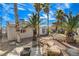 Charming backyard featuring desert landscaping, mature palm trees, and private retreat at 132 Continental Ave, Henderson, NV 89015