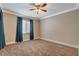 View of carpeted bedroom with base molding and a ceiling fan and blue curtains at 132 Continental Ave, Henderson, NV 89015